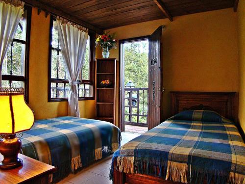 a bedroom with two beds in a room with a window at Villa Salomé Apartamentos Turísticos in Duitama