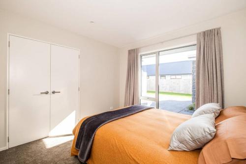 a bedroom with a bed and a large window at Home away from home Methven in Methven