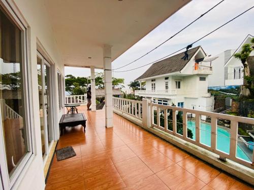 a balcony with a view of a house and a pool at Villa Benny Gsp Cipanas in Cibadak
