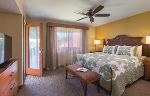 Club Wyndham Kona Hawaiian Resort في كيلوا كونا: غرفة نوم بسرير ومروحة سقف