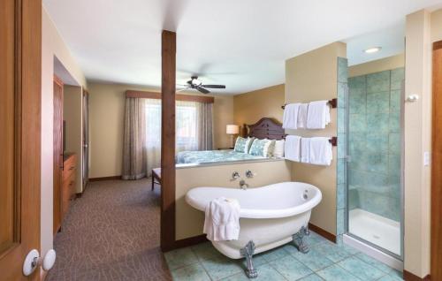 Club Wyndham Kona Hawaiian Resort في كيلوا كونا: حمام مع حوض استحمام وسرير