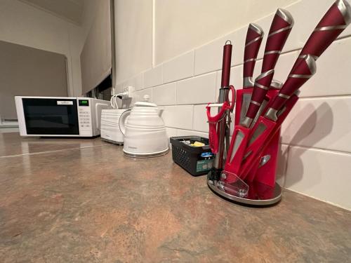 a kitchen counter with a cup of utensils and a microwave at Private 1 Bedroom Apartment with Fenced Yard in Grafton