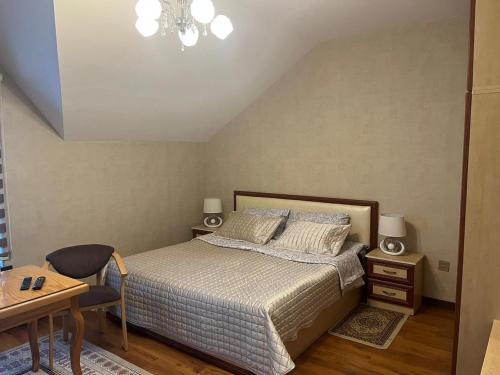 a bedroom with a bed and a table and a desk at Beautiful Guest House Qusar in Qusar