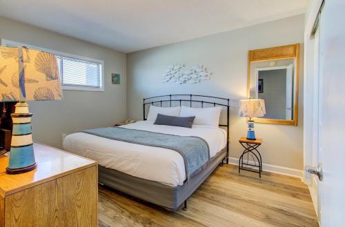 a bedroom with a bed and a table and a mirror at 1010 Relax, Unwind, Enjoy by Atlantic Towers in Carolina Beach