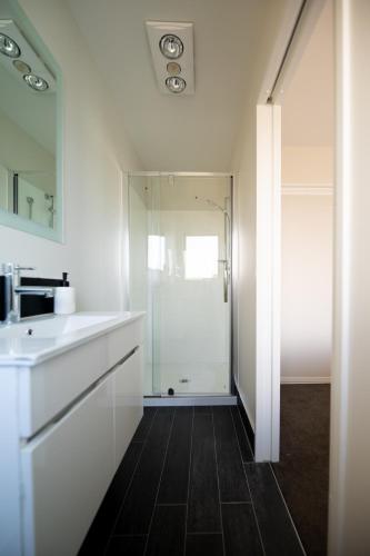 a white bathroom with a sink and a shower at TekapoSpace in Lake Tekapo