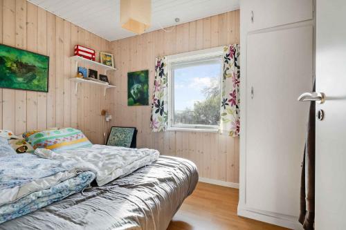 a bedroom with a bed and a window at Bogns Cabin in Holbæk