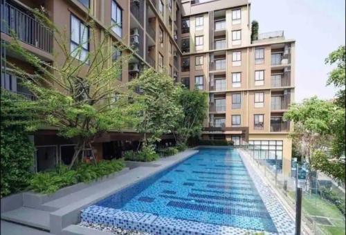 an apartment complex with a swimming pool in front of a building at 2 Bedroom Nice Location @ BTS onnut in Bang Chak