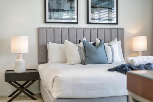 una camera da letto con un grande letto bianco con due lampade di Oracle Resort Broadbeach - GCLR a Gold Coast
