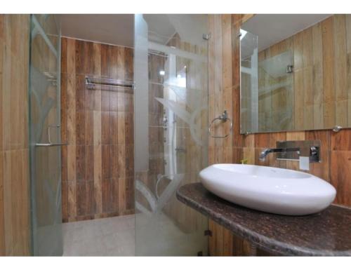 Milan Residential, Muzaffarpur في مظفربور: حمام مع حوض ودش زجاجي