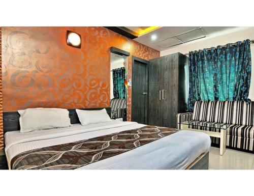 a hotel room with two beds and two chairs at Milan Residential, Muzaffarpur in Muzaffarpur
