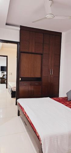 sypialnia z 2 łóżkami i drewnianą szafką w obiekcie Family 3bhk Home stay! w Nowym Delhi