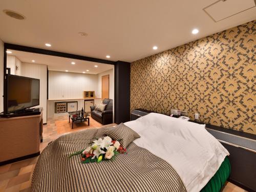 Restay DEE (Adult Only) في توكوشيما: غرفة نوم بها سرير كبير وعليه زهور