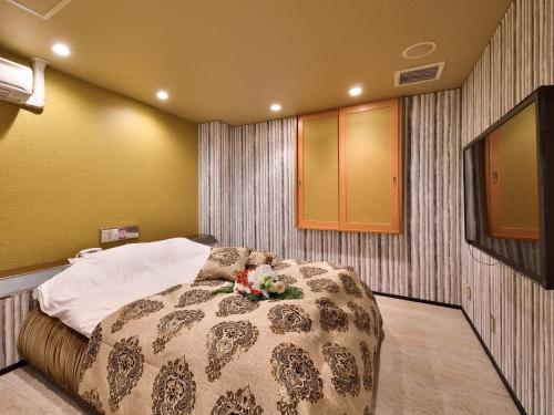 a bedroom with a bed with flowers on it at Restay DEE (Adult Only) in Tokushima
