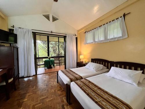1 Schlafzimmer mit 2 Betten und einem großen Fenster in der Unterkunft Eden Nature Park and Resort in Davao City