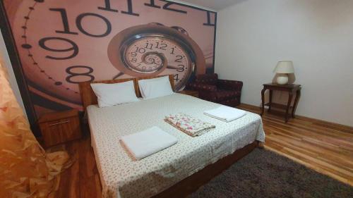 a bedroom with a bed with a clock on the wall at Guest rooms KRASI 