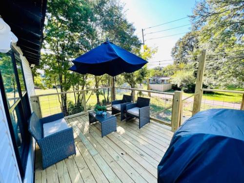 a patio with a blue umbrella and chairs on a deck at Group Stay 3bd 2bth Ask about Deals in Birmingham