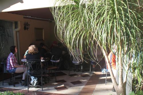a group of people sitting at tables in a patio at Hotel Santa Maria Inn in Alajuela City