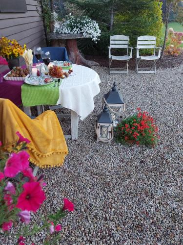 a table and chairs in a backyard with flowers at Apartamenti Dundaga XXL in Dundaga