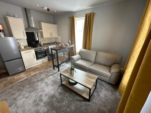 a living room with a couch and a table at O’er The Yard Hideaway in Blackpool