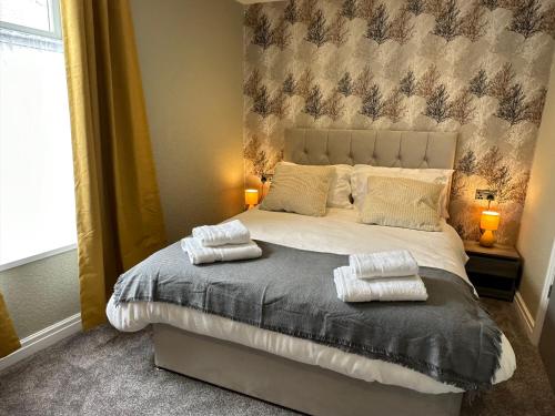a bedroom with a bed with two towels on it at O’er The Yard Hideaway in Blackpool