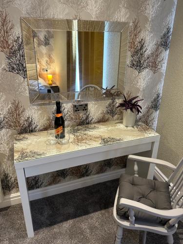 a bathroom with a vanity with a mirror and a chair at O’er The Yard Hideaway in Blackpool