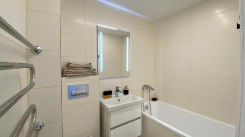 a white bathroom with a sink and a mirror at C3 apartment in Kėdainiai in Kėdainiai