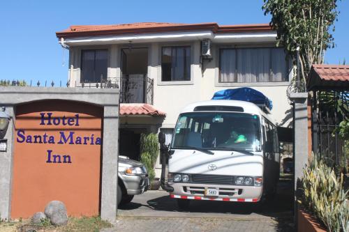 a white van parked in front of a house at Hotel Santa Maria Inn in Alajuela City