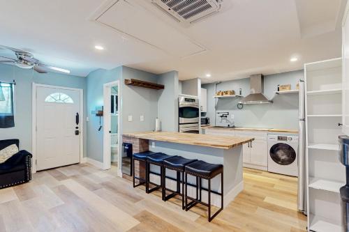 een keuken met blauwe muren en een aanrecht met krukken bij Linden Way Studio in La Mesa