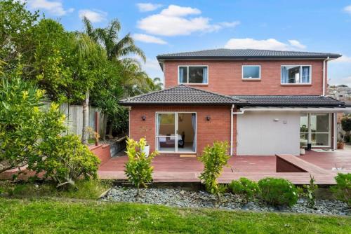 a house with a wooden deck in the yard at Albany Bolthole with Queen Beds and Kitchenette in Auckland