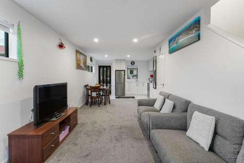 a living room with a couch and a tv at Stunning 2BR in Kelston - WIFI - Carpark in Auckland