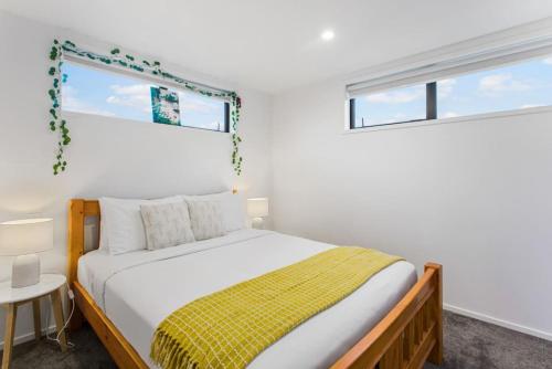 a bedroom with a bed with a yellow blanket at Stunning 2BR in Kelston - WIFI - Carpark in Auckland