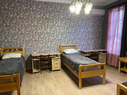 Un dormitorio con dos camas y una mesa y sillas. en Family Apartments "IGWT", en Tiflis