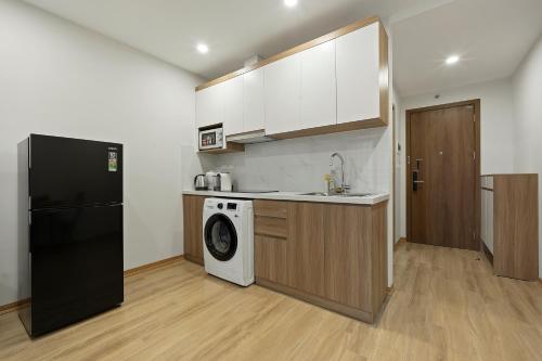 a kitchen with a black refrigerator and a washing machine at 22housing Residence Suites in Hanoi