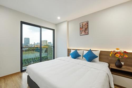 a bedroom with a large bed and a large window at 22housing Residence Suites in Hanoi