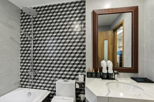 a bathroom with a sink and a toilet and a mirror at 22housing Residence Suites in Hanoi