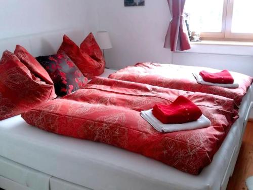 Duas camas com cobertores vermelhos e almofadas em Bad Sankt Leonhard em Klippitztorl
