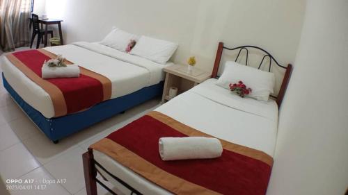 duas camas sentadas uma ao lado da outra num quarto em Anggerik Heights Homestay em Bentong