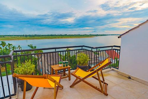 - un balcon avec deux chaises et une vue sur l'eau dans l'établissement HA Mountain View Pool Villa, à Hội An