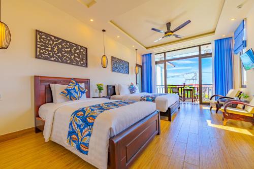 Un dormitorio con dos camas y un balcón. en HA Mountain View Pool Villa, en Hoi An