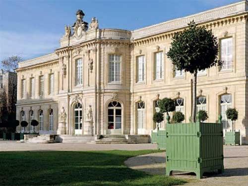 a large building with a tree in front of it at Chez Alex in Asnières-sur-Seine