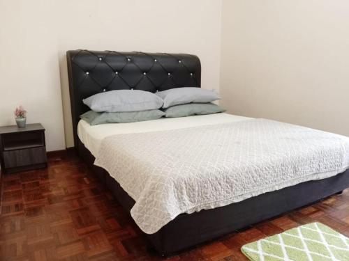 Kampong Tanah Merahにある2 Bedroom Rangalau Homestay with Wifi plus Balconyのベッドルーム1室(黒いヘッドボード付)