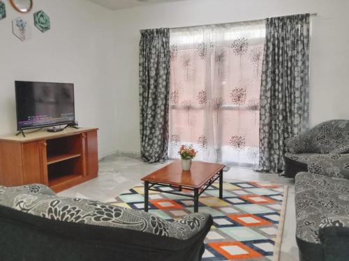 Kampong Tanah Merahにある2 Bedroom Rangalau Homestay with Wifi plus Balconyのリビングルーム(椅子2脚、テーブル、テレビ付)