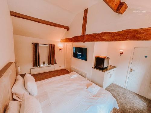 a bedroom with a white bed and a tv at Ye Olde Original Withy Trees in Bamber Bridge