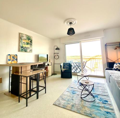 un salon avec une table et un canapé dans l'établissement Studio DUNES de NALA avec balcon vue Dunes et latérale Mer pour 4 pers 100m plage wifi ménage compris, à Fort-Mahon-Plage