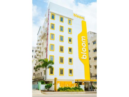 a white building with a yellow sign on it at Bloom Hotel - Cyber Towers in Hyderabad