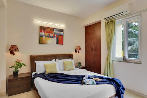 um quarto com uma cama grande e uma janela em Veeraas Calangute - 2BHK Apartment with Pool em Marmagao