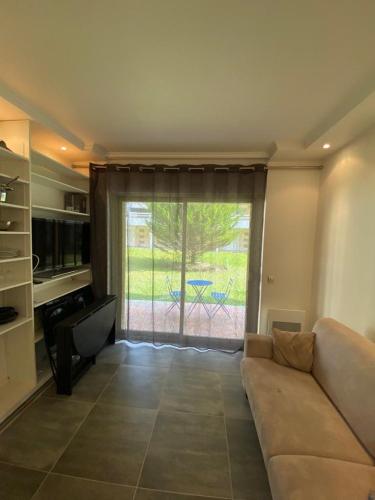 un salon avec un canapé et une grande fenêtre dans l'établissement Studio deauville Situé devant la plage, à Deauville