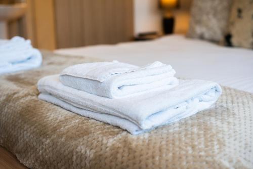 a pile of towels sitting on top of a bed at The George & Dragon Country Inn in Seaton