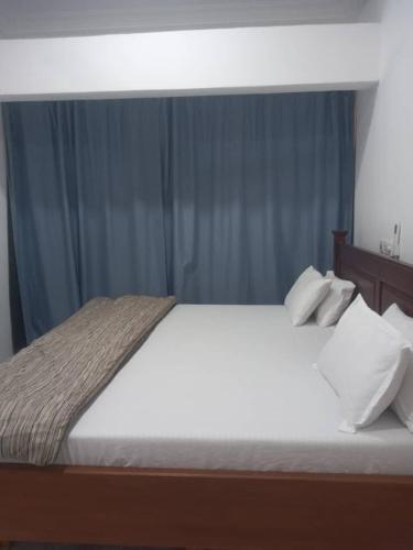 a bedroom with a bed with white sheets and pillows at nanas@TEMA C11 in Tema