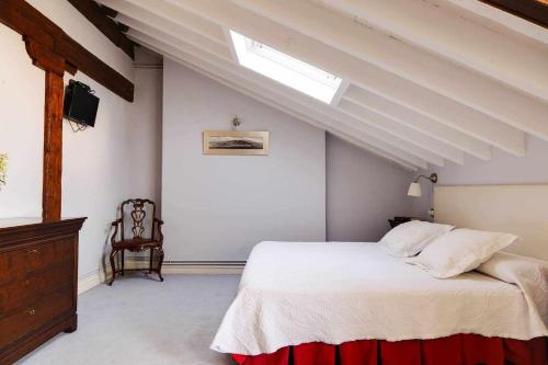 a bedroom with a white bed and a skylight at ático vistas centro 3min playaparking y wifi free in Laredo